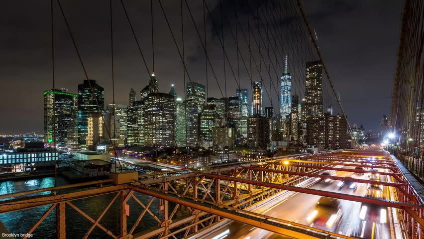 Night city bridge with traffic light trails and illuminated skyline.