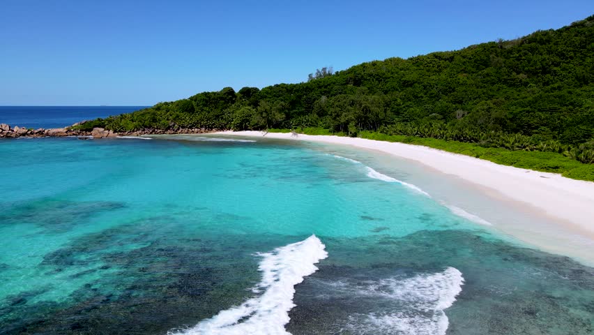 Discover the stunning turquoise waters and soft white sands of Anse Cocos beach on La Digue Island. The serene atmosphere invites visitors to relax and enjoy a peaceful day in paradise Seychelles.