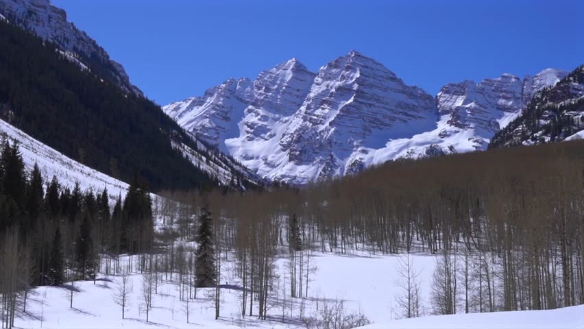 Maroon Bells North Maroon Peak Snowy Aspen Colorado Winter Spring time Rocky Mountains Maroon Lake snowmobile hiking deep snow powder sunny morning blue sky Capitol Peak Lazy 7 ranch tour zoom out