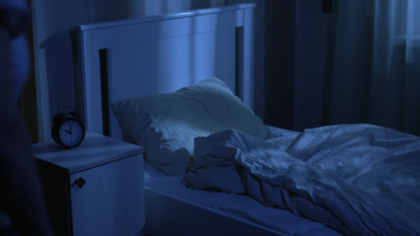Elderly woman getting into bed at night routine