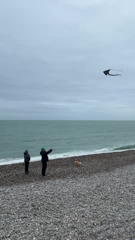 Exploring the beach at Etretat, France with family and dog during cloudy afternoon	

