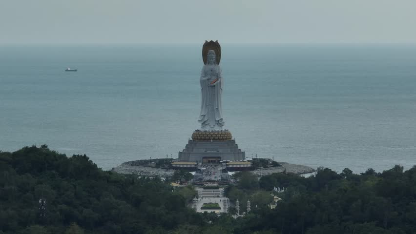 Aerial footage of Guanyin statue at seaside in nanshan temple, hainan island , China. Words mean mercy and blessing