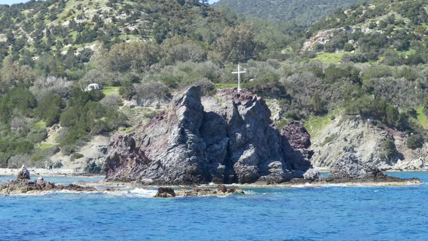 Rocky coastline with clear blue water in Cyprus. Mediterranean tourism destination with natural scenery. Sea cliffs and coastal landscape under sunlight. Volcanic rock of Gabor, Aphrodite