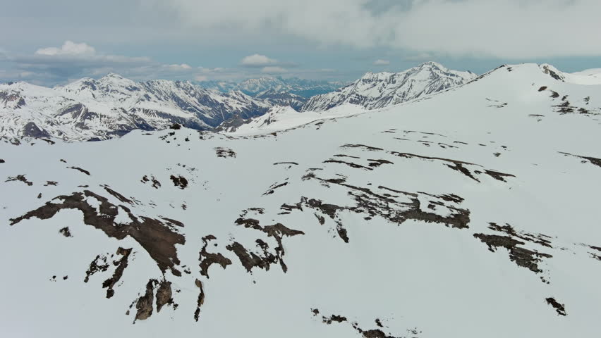 Aerial around view of snow mountain range landscape with clouds. Alps mountains, Austria, 4k