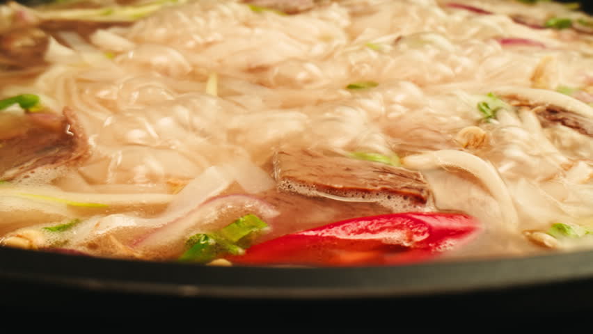 Vietnam traditional pho bo soup on delivery, Beef noodles. Pho Bo Soup with beef, rice noodles, ginger, lime, chili pepper in bowl. Vietnamese cuisine. Pho Noodle Soup restaurant Close-up.