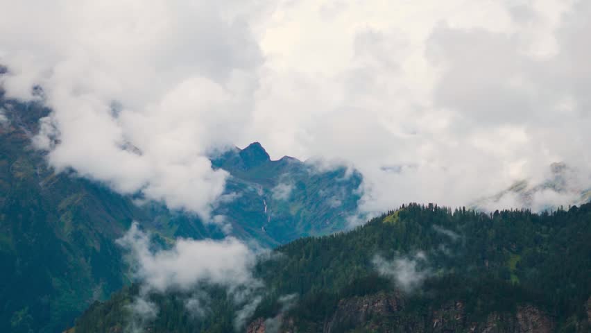 Serene landscape of green Himalaya mountains covered with clouds as seen from Bhrigu lake trek in Manali, Himachal Pradesh, India. Monsoon in mountains. Travel and holidays concept. Nature background.