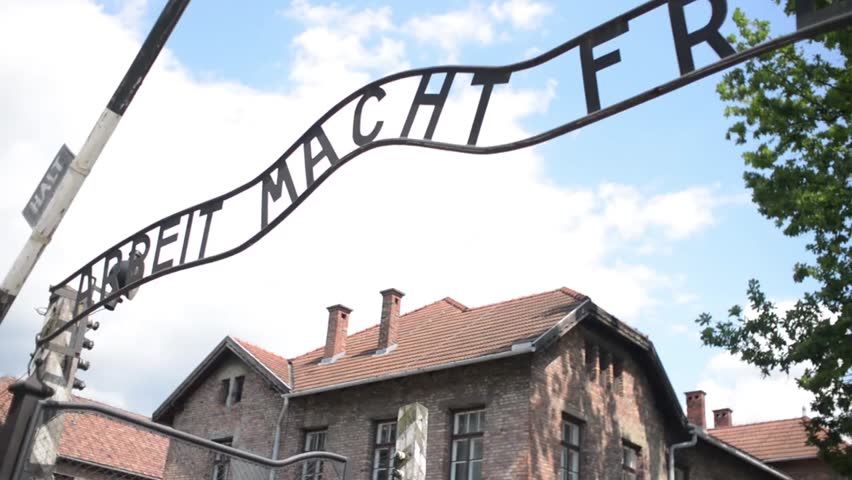 Auschwitz concentration camp barracks with barbed wire fencing, historic World War II memorial site in Poland used for remembrance and education