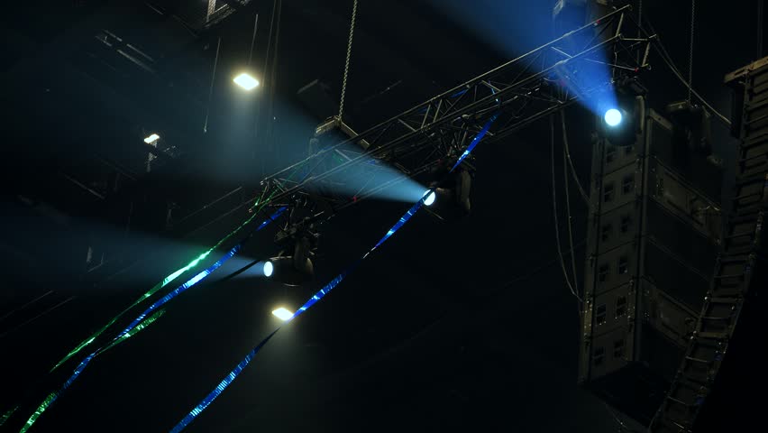 Performing concert stage with bright lighting, sound system, and truss structure