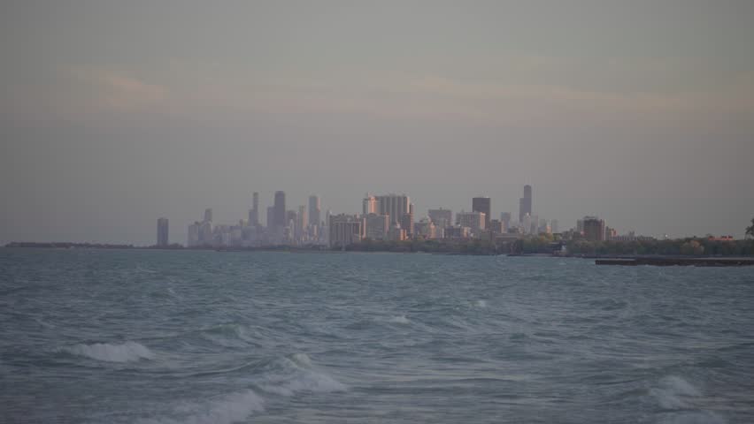 City Skyline Across Lake with Rolling Waves