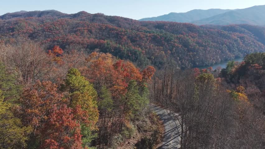Cinematic aerial footage of the emerald waters of Fontana Lake surrounded by the vibrant autumn colors of the Great Smoky Mountains.