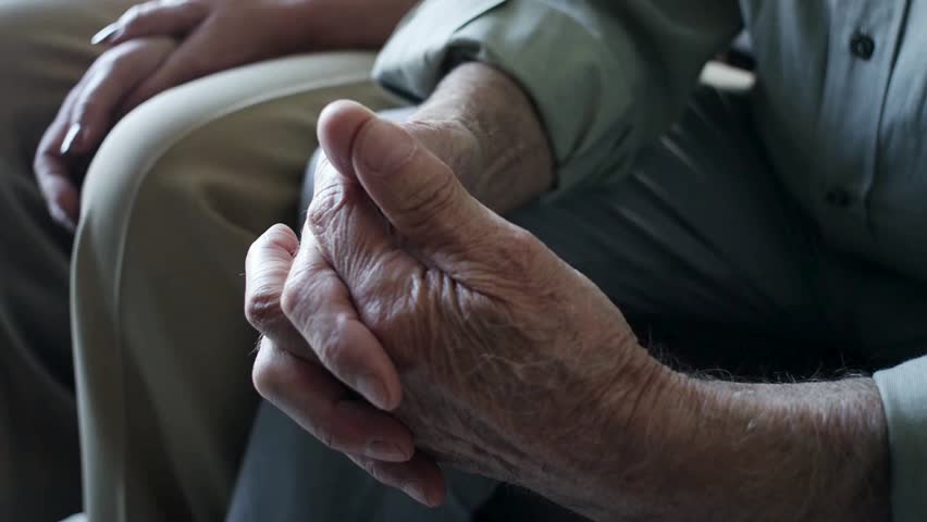 Senior woman putting her hand on her husbands while sharing moments of bonding. Affectionate elderly married couple having bonding moments together.
