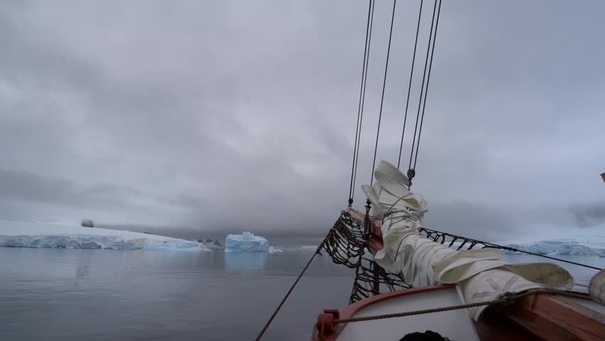 Cinematic POV shot from the bowsprit of the Schooner Amazone sailing through the Errera Channel toward Georges Point, Rongé Island, Antarctica
