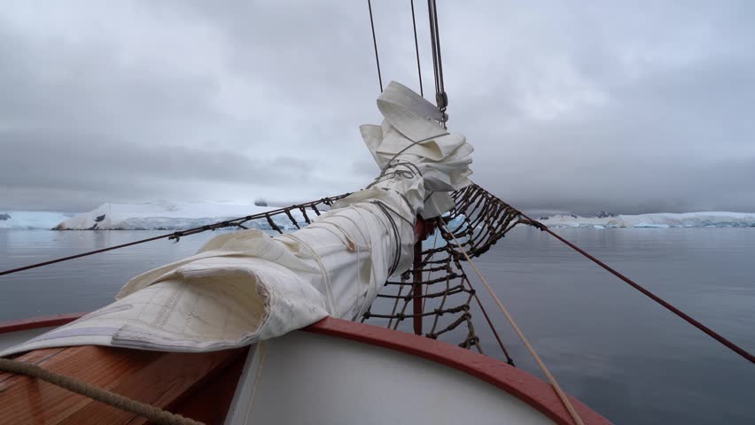 Cinematic POV shot from the bowsprit of the Schooner Amazone sailing through the Errera Channel toward Georges Point, Rongé Island, Antarctica