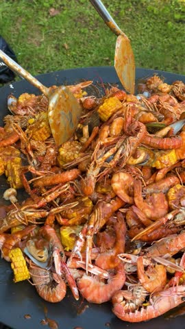Assorted seafood including prawns, mussels, clams, grilling on a barbecue, authentic dining experience. 