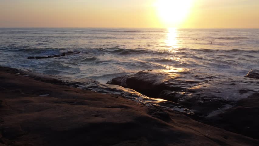 Waves Crashing on Cliff Rocks at Sunset near Windansea Beach which is a stretch of coastline in the La Jolla community of San Diego, California.