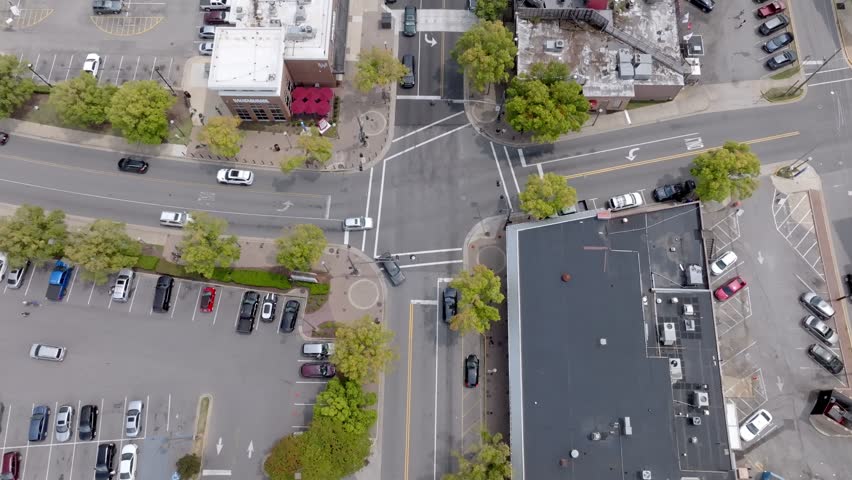 Downtown intersection in Tuscaloosa, Alabama with skyline view and drone video tilting up.