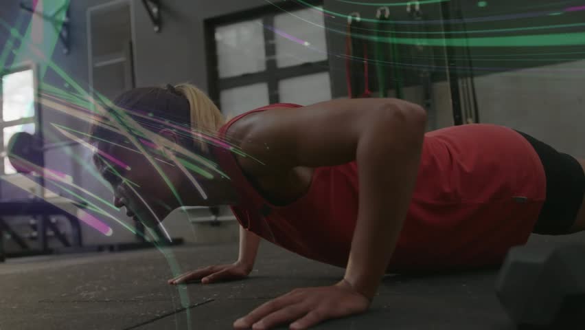 Woman starting lowered pushup exhaling doing pushups for fitness in gym overlay swirling over frame. Athlete, female, sideview, lowangle, sunlight, facility, strength