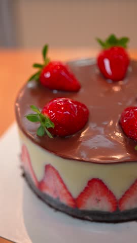 Layered Strawberry Cake with Chocolate Sauce and Cream on Rotating Stand Vertical Video