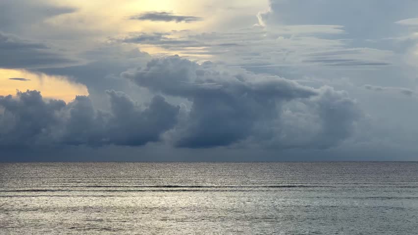 Dramatic cloudy sky over vast ocean with textured water and wide horizon, powerful seascape background
