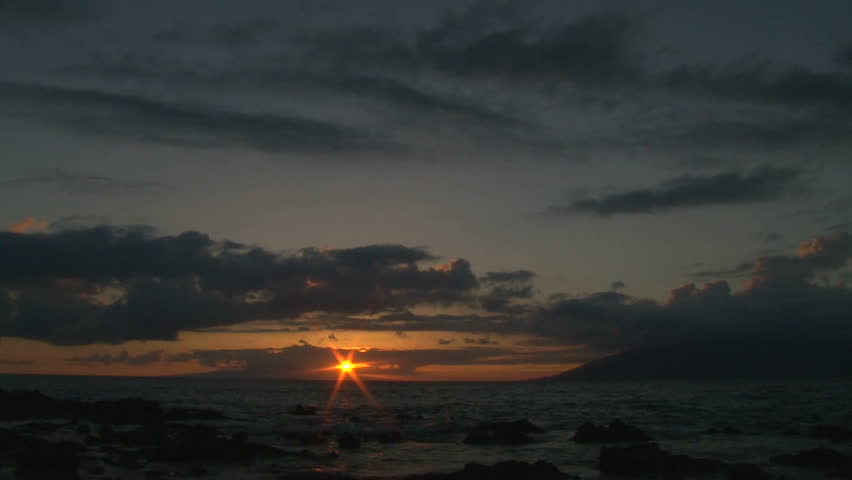 Final light of sun going down over Pacific Ocean from beach, twilight in Hawaii.