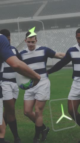 Vertical video: Rugby team huddling as #7 turning, ball, green icons floating over players pregame. Stadium, outdoor, grass, field, circle, huddle, vertical video