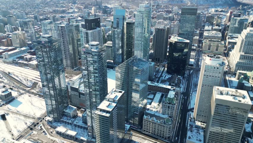 Aerial drone view of the Montreal skyline, Quebec, Canada, captured in 4K resolution. Modern cityscape featuring skyscrapers, urban architecture, and the downtown business district of a major North American city.