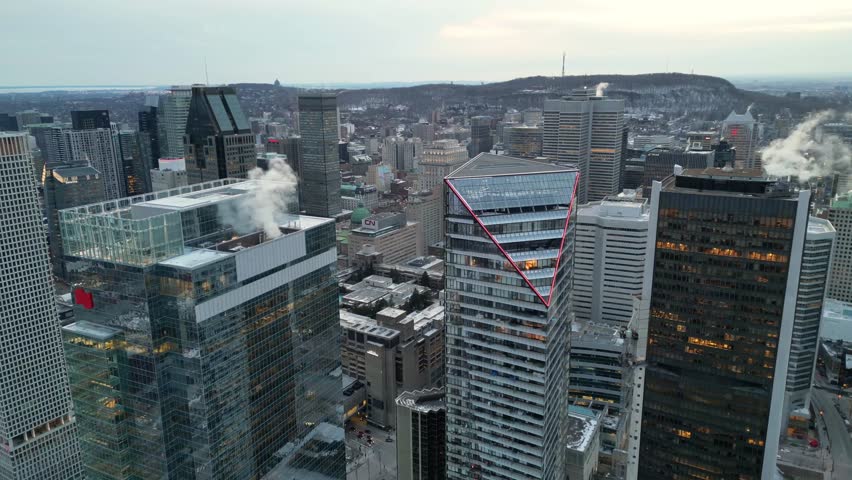 Aerial drone view of the Montreal skyline, Quebec, Canada, captured in 4K resolution. Modern cityscape featuring skyscrapers, urban architecture, and the downtown business district of a major North American city.