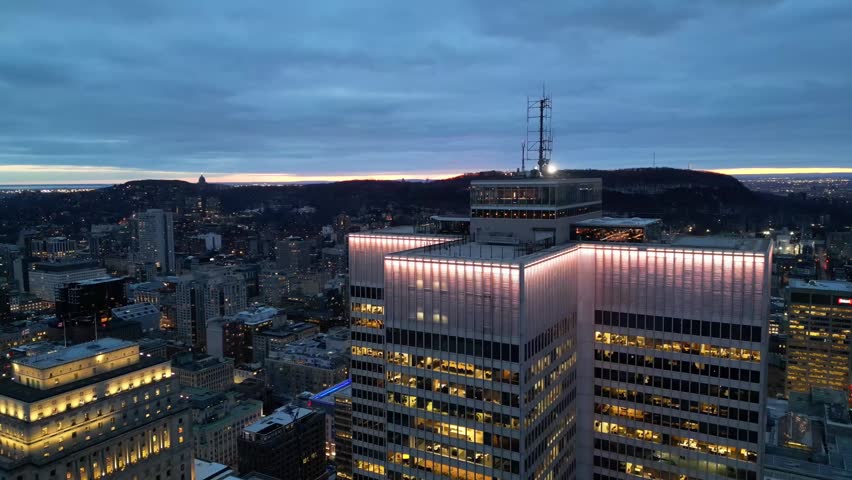 Aerial night view of Montreal downtown skyline with illuminated city lights, Quebec, Canada in 4K. Cinematic urban cityscape featuring skyscrapers and modern architecture, ideal for commercial use, travel and business concepts.