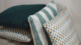 Smooth camera motion showing plush velvet and patterned throw pillows arranged on cozy seating in bright interior space. - Powered by Shutterstock - Get 15% off with code: PIKWIZARD15