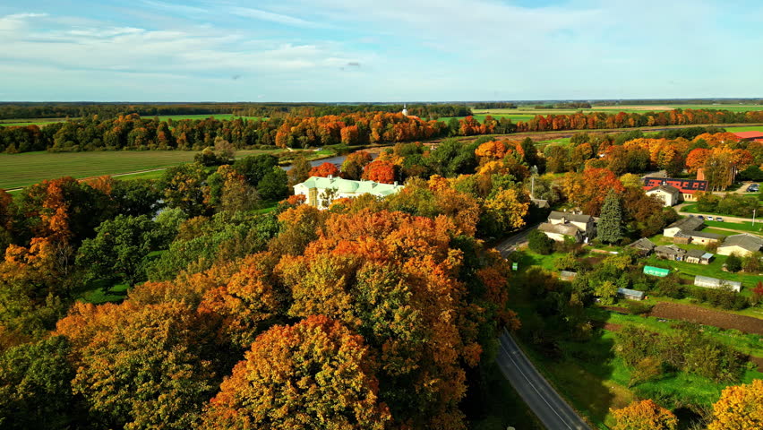 Drone footage reveals the vibrant orange autumn foliage surrounding the historic Malnava College in Latvia.