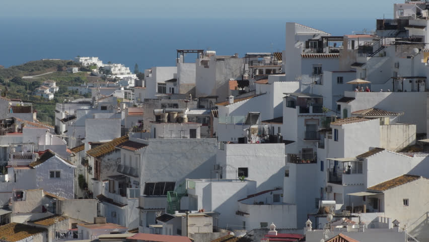 Houses and buildings packed together on a hillside near the ocean