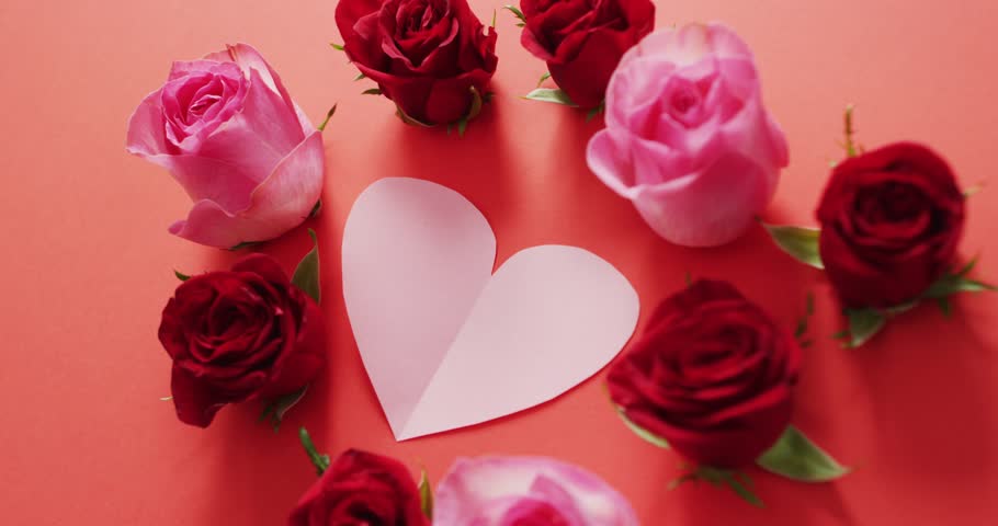 Red and pink roses with heart on red background at valentine