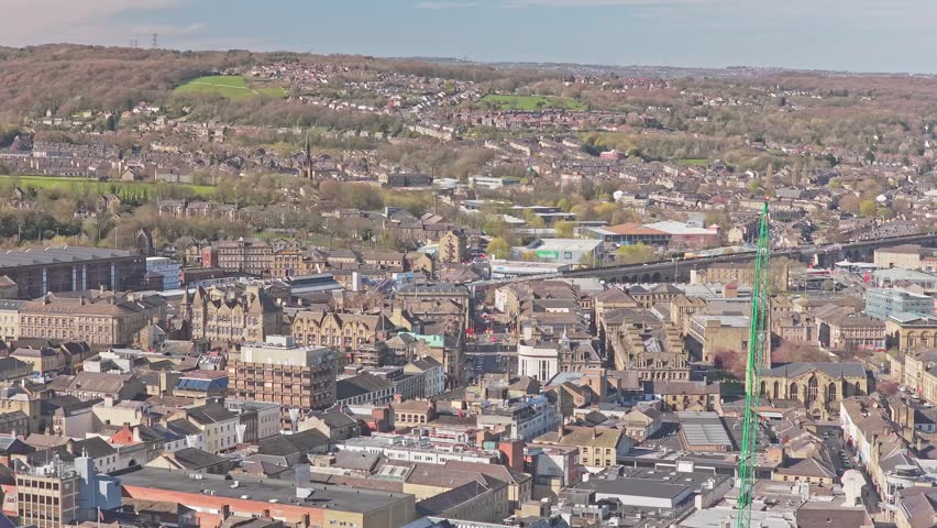 Huddersfield town centre with Huddersfield Railway Station St Georges Square and Town Hall in Kirklees West Yorkshire England United Kingdom with rail corridor, lateral pan right drone shot