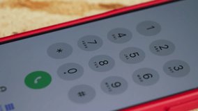 A close-up of a smartphone screen, with a finger dialing a number. The scene highlights the importance of communication, mobile technology, and everyday digital interaction. High quality 4k footage - Powered by Shutterstock - Get 15% off with code: PIKWIZARD15