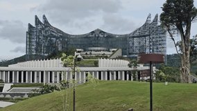 Garuda palace in Nusantara capital city Indonesia blends with nature and green spaces. Concrete pathways lead to a grand, structured building. Skyline features a dramatic, angular glass facade - Powered by Shutterstock - Get 15% off with code: PIKWIZARD15