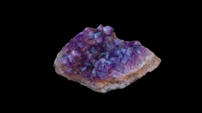 A purple amethyst druse isolated on a black background in loop