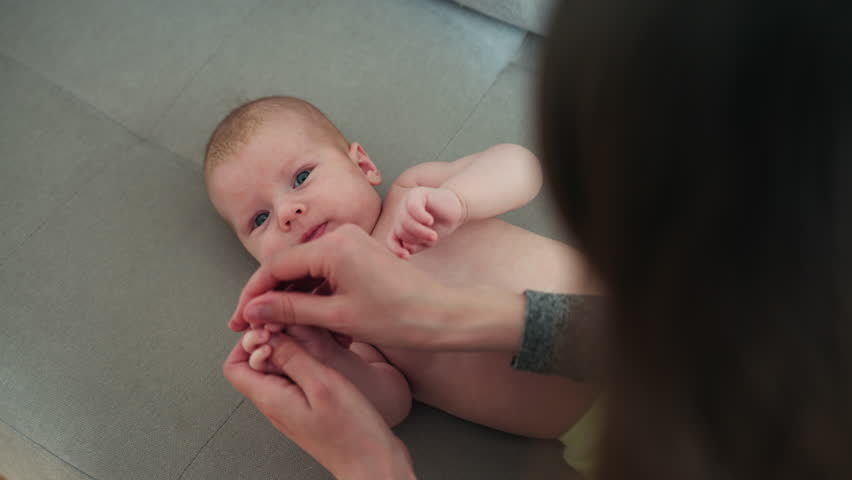 Parent gently massages infant