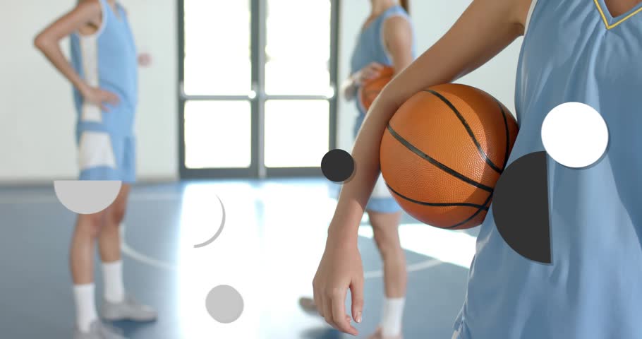 Graphics appearing from sides, stacking across frame while right player holding ball, forming grid. Basketball, gymnasium, teammates, backlight, geometry, overlays, kinetic