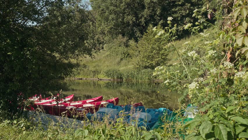 Peaceful river with moored canoes surrounded by natural greenery