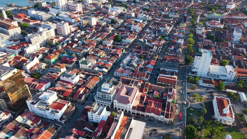 Aerial view of George Town, the old town in Penang, with dense heritage buildings and colorful rooftops, showcasing historic architecture and urban layout in Southeast Asia. UHD.