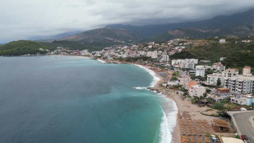 Stunning Aerial View of Scenic Coastal Town, High-angle aerial view of a picturesque coastal town nestled along a blue bay.