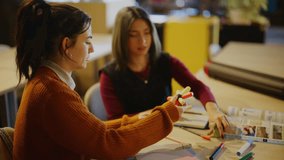 Young women students are focused on assembling a colorful educational model at a table. The scene captures two students engaged in hands-on learning and collaborative study. - Powered by Shutterstock - Get 15% off with code: PIKWIZARD15