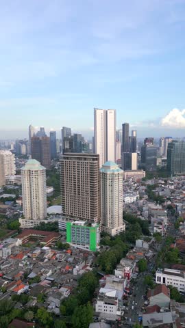 Aerial view of Jakarta skyline with high-rise buildings and dense residential housing. Urban cityscape showing population density, development and modern architecture in Indonesia.