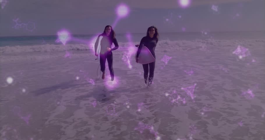 Two surfers running toward camera in shallow water after surfing, purple particle overlay on boards. Beach, ocean, waves, sand, duo, friends, jogging