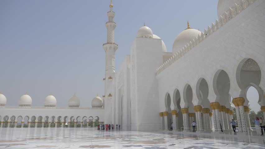 White mosque in Abu Dhabi. Vast marble courtyard surrounded by domes and colonnades