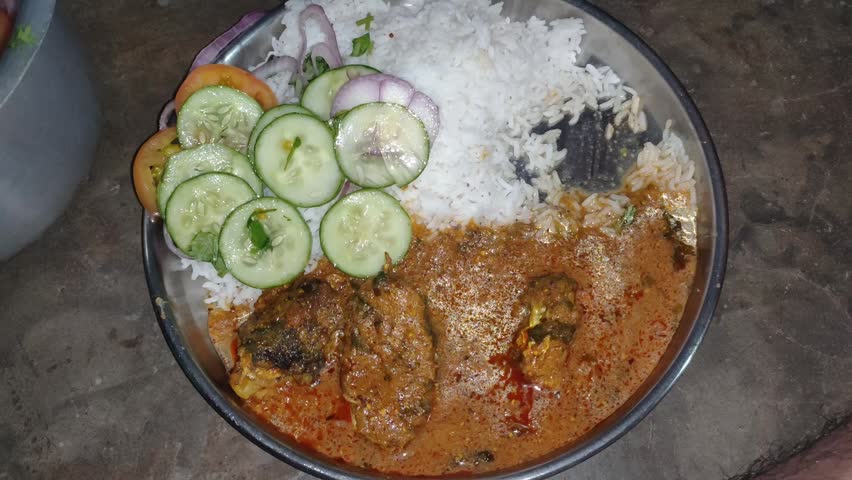 A plate of rice and fish with cucumber salad