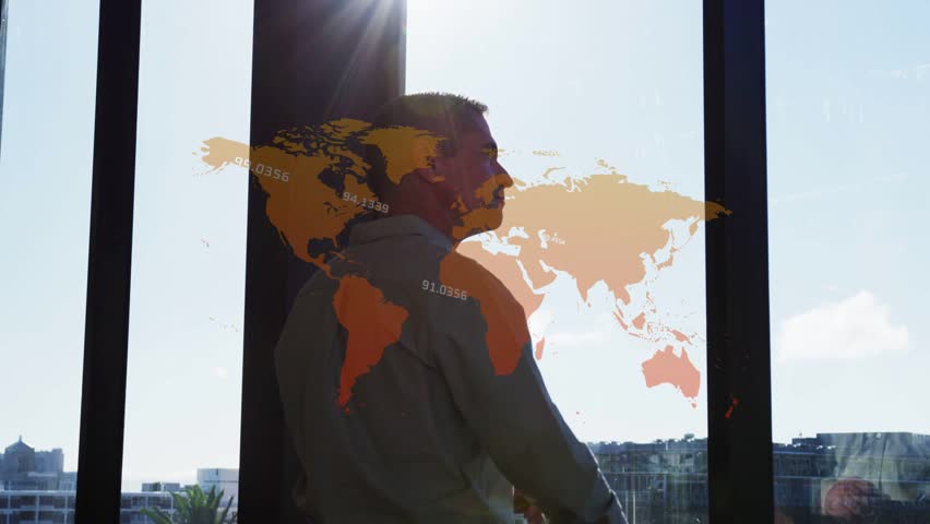 Man standing by glass window at office, wearing button-up shirt, studying orange world map overlay. Mature, contemplation, cityscape, sunlight, flare, focus, executive