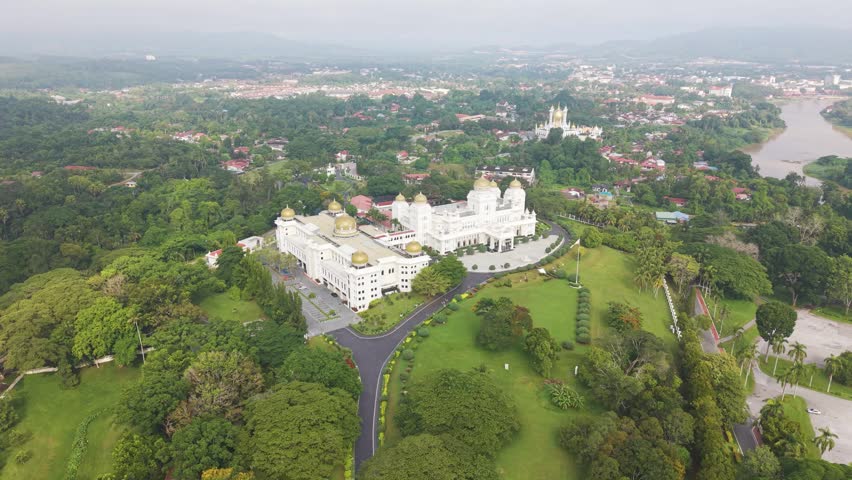 Orbiting aerial view of Istana Iskandariah royal palace in Kuala Kangsar, Malaysia, surrounded by lush greenery. Scenic landscape showcasing royal heritage, architecture.