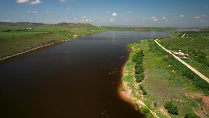 Grassland and Stream Under Clear Blue Sky 4K Aerial