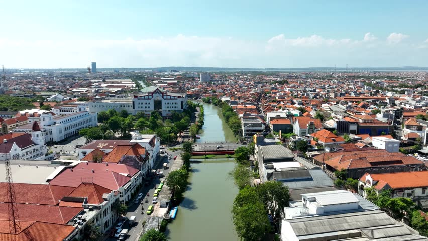 Aerial Dolly In Over Red Bridge and Kali Mas River, Surabaya Indonesia Historic Urban Skyline